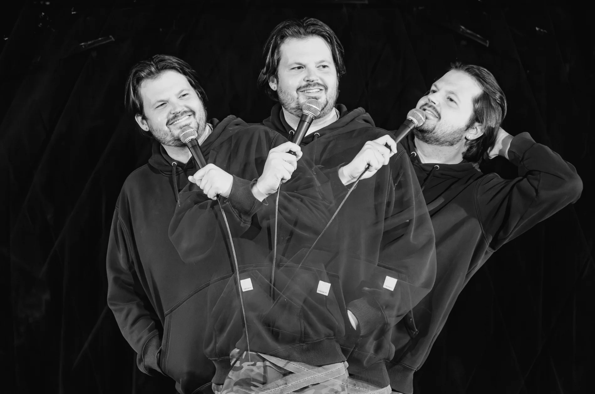 Black-and-white triple exposure of Matt Lockwood performing with a microphone